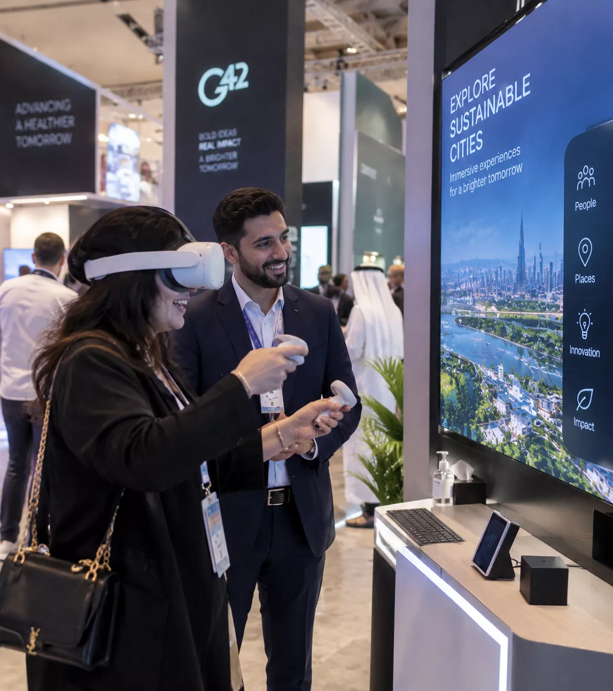 a-woman-wearing-a-vr-headset-gestures-during-a-live-demo-beside-a-colleague-in-front-of-a-g42-display-promoting-sustainable-cities