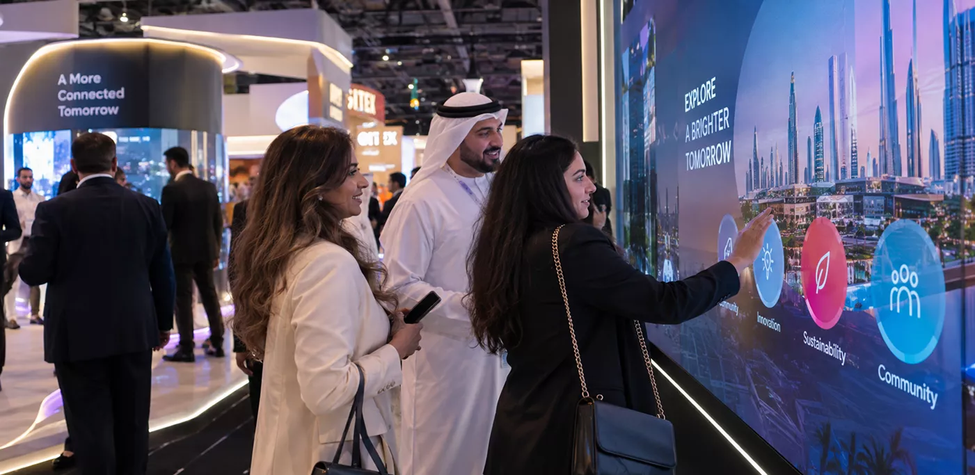 exhibition-visitors-interacting-with-a-large-touchscreen-wall-displaying-sustainability-innovation-and-community-icons-under-the-message-explore-a-brighter-tomorrow